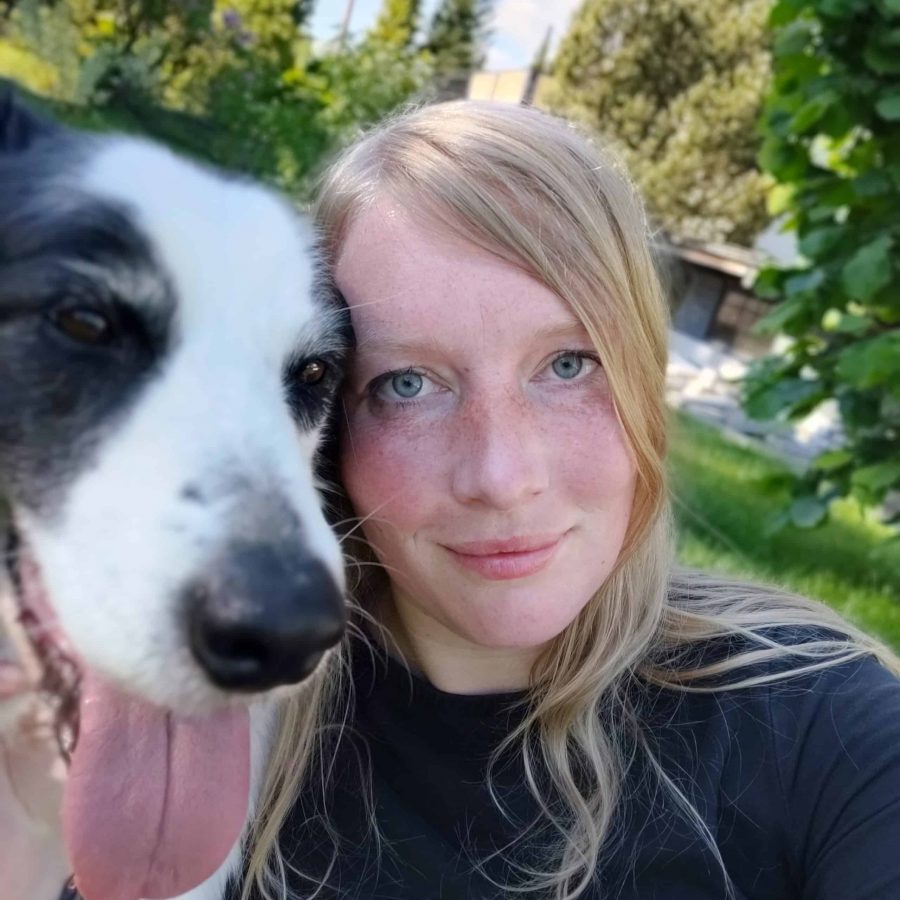 Hundetrainerin Sonja und Border Collie Hündin Leela blicken nebeneinander direkt in die Kamera beim Training an einem Sommertag in der Hundeschule Hof.